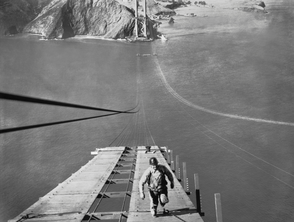 A worker running up one of the catwalks being built for the construction of the cable of the Golden Gate Bridge, September 19, 1935. Source: Getty