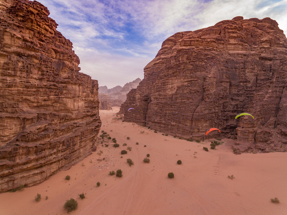 Paramotors flying into a narrow gorge in Jordan’s spectacular Wadi Rum, shot from a drone (credit: Fergus Kennedy)