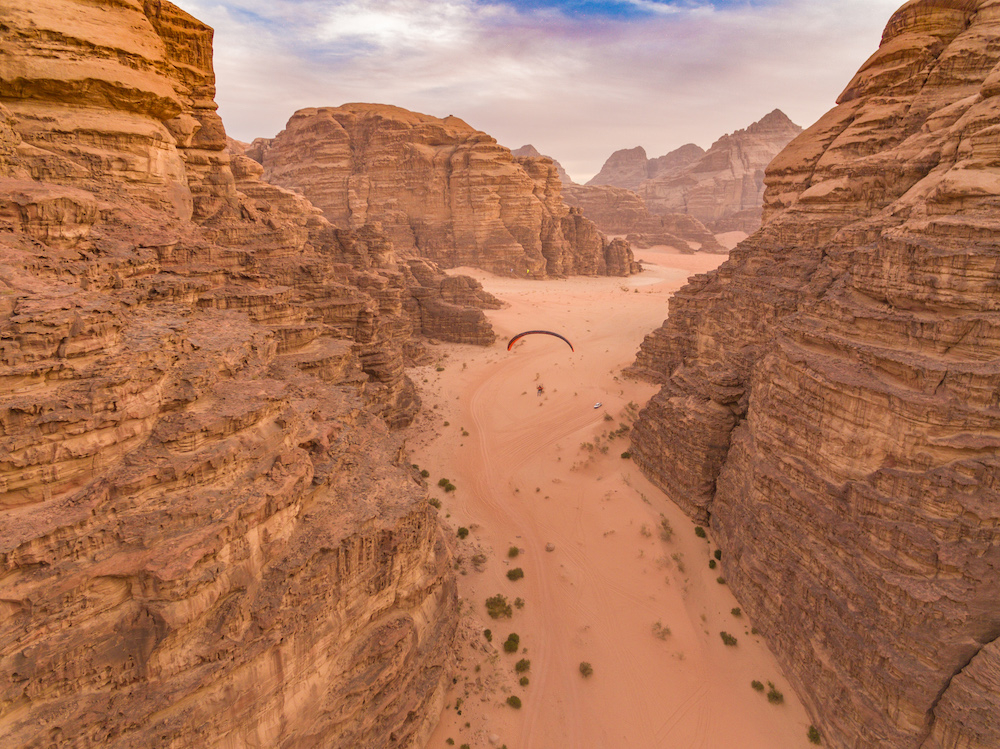 Paramotor pilot Stefan Fritz flies through a gorge in Wadi Rum, shot from a drone (credit: Fergus Kennedy)